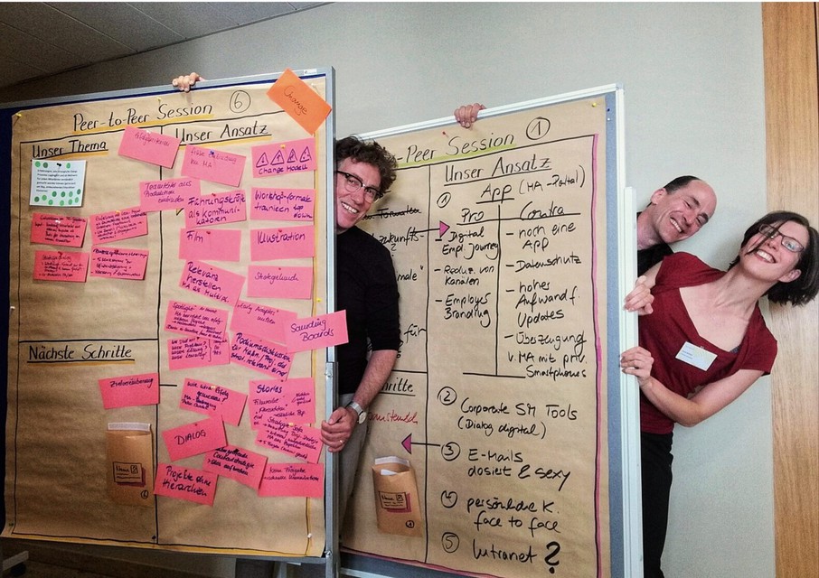 Mitarbeiter im Büro verstecken sich hinter Pinboards